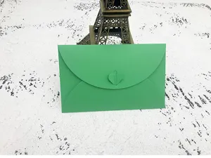 Detail shot of green paper envelope with heart clasp, ideal for letters and greeting cards.