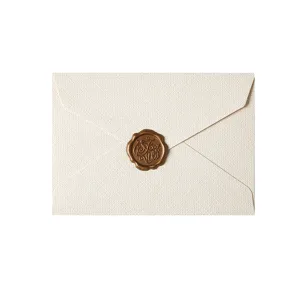 Detail view of vintage beige textured envelope with elegant bronze wax seal for romantic letters.