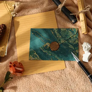 Ensemble de papeterie rétro avec enveloppe marbrée verte, papier à lettres ligné et sceau.