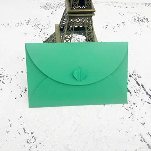 Detailed close-up view of a vibrant green paper envelope featuring a cute heart-shaped clasp closure.