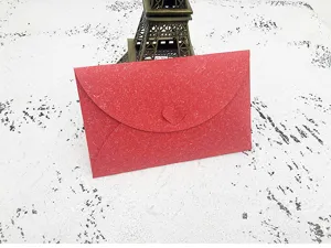Red paper envelope detail shot, creative heart clasp design, elegant stationery style.