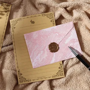 Ensemble de papeterie vintage avec lettre en kraft, enveloppe en marbre rose et sceau de cire.