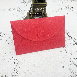 Red textured envelope detail shot featuring a sweet heart clasp and elegant paper craft finish.