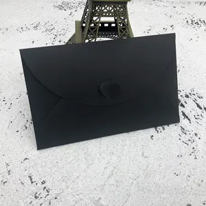Detail view of black paper envelope featuring a charming heart-shaped clasp design for letters.