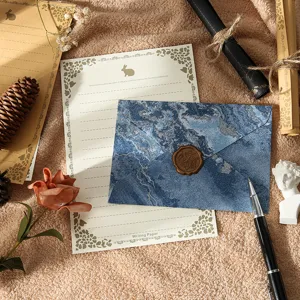 Vue détaillée d'une enveloppe vintage texture marbre bleu et papeterie motif lapin.