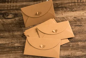 Detailed view of brown kraft paper envelopes featuring creative heart-shaped clasps for letters.