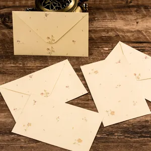 Vintage floral stationery envelope detail, retro paper texture with delicate tiny flower patterns.