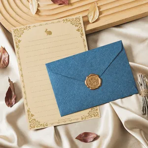 Vintage stationery set with kraft writing paper, blue envelope and gold wax seal decor.