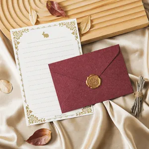 Vintage stationery set with retro letter paper, burgundy envelope, and golden wax seal.