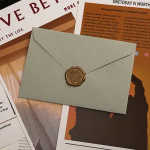 Gros plan de l'enveloppe texturée vert clair avec cachet de cire sur journal rétro.