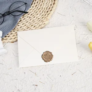Detailed view of cream-colored envelope with wax seal stamp, styled with minimalist props.