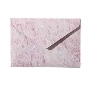 Primo piano dettagliato di busta in carta strutturata retrò rosa, elegante stile vintage.