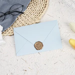Light blue envelope set detail shot featuring a delicate gold wax seal and paper stationery.