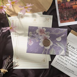 Vintage floral stationery set with purple envelope, gold-bordered writing paper, wax seal.