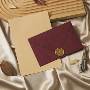 Close-up detail of retro stationery set featuring dark red envelope and vintage kraft paper.