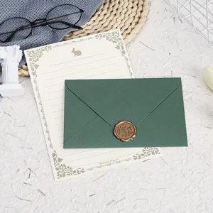 Vintage stationery set with dark green envelope, elegant letter paper and wax seal stamp.