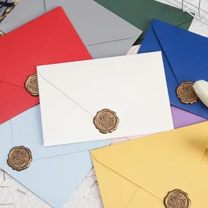 Close-up detail of colorful pearl paper envelopes with retro wax seal stamp for invitations.