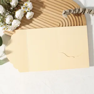 Gros plan détail d'une enveloppe de carte de vœux beige pliée en trois avec bordure.