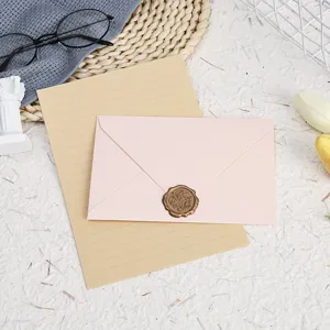 Detailed view of pink envelope with vintage wax seal stamp and lined stationery paper.