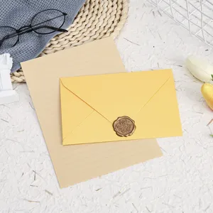 Close-up detail of yellow stationery envelope and lined paper set with vintage wax seal.