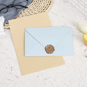 Detailed shot of vintage stationery set with blue envelope, lined paper and wax seal.