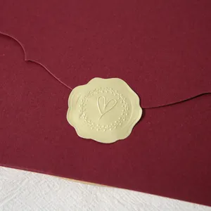 Enveloppe en papier bordeaux avec autocollant de sceau de cœur doré, invitation de mariage.