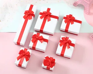 Colección de cajas de regalo blancas en varios tamaños con lazos de cinta roja