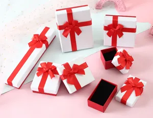 Variedad de cajas de regalo para joyas blancas con lazos rojos e interior de terciopelo negro