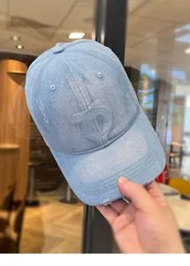 Berretto da baseball in denim azzurro con lettera ricamata e visiera usurata donna.