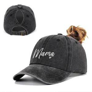 Close-up detail of a washed grey ponytail baseball cap featuring Mama heart embroidery