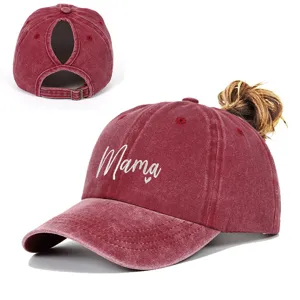 Macro view of washed burgundy baseball cap with Mama embroidery and ponytail hole