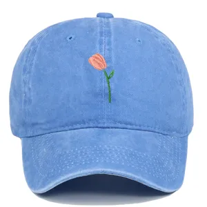 Vue détaillée d'une tulipe rose brodée sur une casquette de baseball en coton délavé bleu