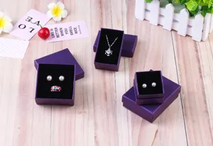 Elegante paarse getextureerde sieradendoosjes met zwarte fluwelen voering voor ringen.