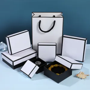 Minimalistische weiße Schmuckschachteln mit schwarzem Rand und passender Papiertüte