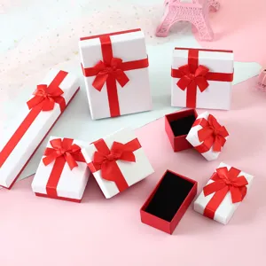 Juego de cajas de regalo para joyas blancas con lazos rojos brillantes y diseño de tapa.