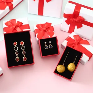 Cajas de regalo para joyas festivas rojas y blancas con lazos de satén elegantes.
