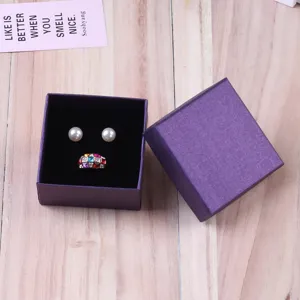 Elegante paarse kartonnen sieradendoos met deksel voor ringen en oorbellen op hout