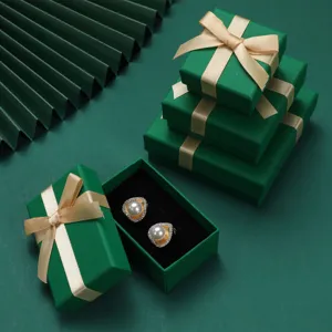 Primo piano di eleganti orecchini di perle in una lussuosa scatola regalo verde