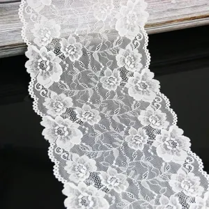 White lace fabric trim detail view, delicate floral pattern for DIY sewing crafts.