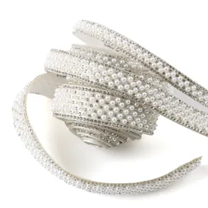 Detailed view of white pearl and rhinestone trim ribbon, perfect for DIY sewing and clothing decor.