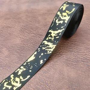 Vista dettagliata del nastro in raso nero e oro marmo 2.5cm per confezioni regalo.