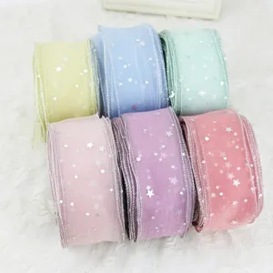 Detalle en primer plano de cintas de organza de colores con estrellas plateadas para regalos.