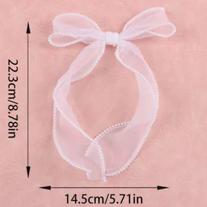 Detail view of white sheer organza bow with pearl trim for gift wrapping and wedding decor.