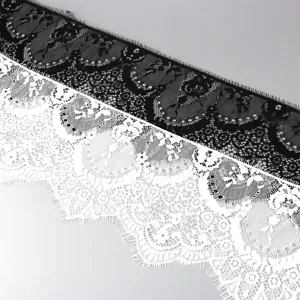 Detailed close-up view of black and white floral embroidered eyelash lace trim for DIY crafts.