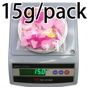 Detail view of pink and gold heart confetti weighed on scale, 15g pack for party decor.