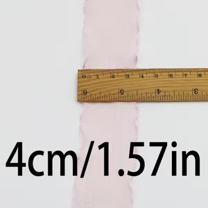 Pink ruffled lace ribbon detail close-up showing 4cm width with a wooden ruler.