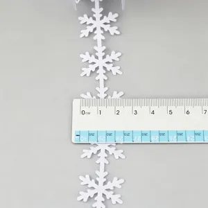White snowflake ribbon detail view showing width measurement with ruler for holiday decor.