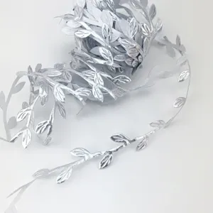 Silver leaf ribbon trim detail showing the exquisite embossed leaf vine texture closely.