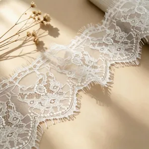 White lace fabric trim ribbon with floral pattern for clothing, sewing, crafts and wedding decor.