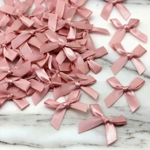 Pink satin ribbon bows detail view, ideal for DIY crafts, sewing, and apparel decoration.